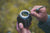 Old man holding a yerba mate gourd and bombilla outside in nature.